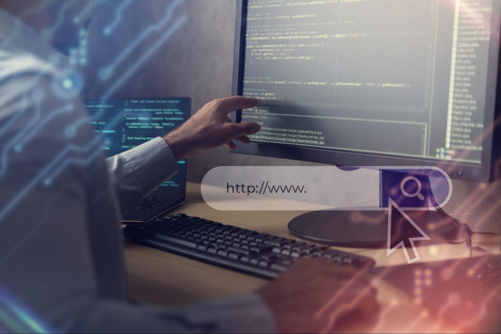 A developer's hand points at code on a computer screen with a web browser search bar overlay showing "http://www." and a search icon.